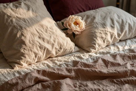 Linen sheets and a peony in warm light - best sex positions for men with a smaller penis article cover